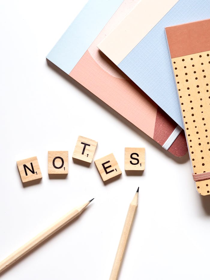 Close-up of educational supplies and wooden alphabet tiles spelling NOTES on a table.
